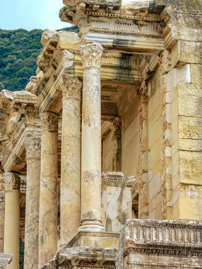 Detailed view of ancient Roman ruins featuring Corinthian columns in historical setting.